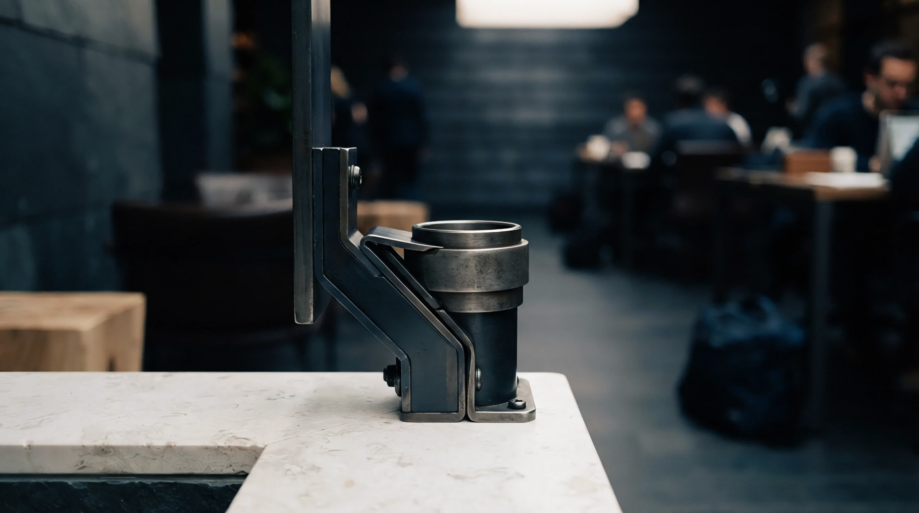 Heavy steel industrial mounting fixture assembly anchored to a polished stone counter inside a modern production facility workspace.